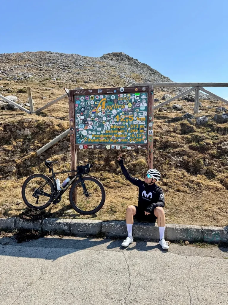 Ciclista subiendo el Angliru entre la niebla, rampas extremas y dureza mítica del puerto asturiano.